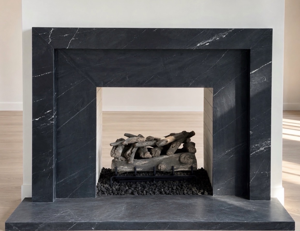 Dark stone fireplace surround with fine white veining, layered rectangular framing and a matching stone hearth