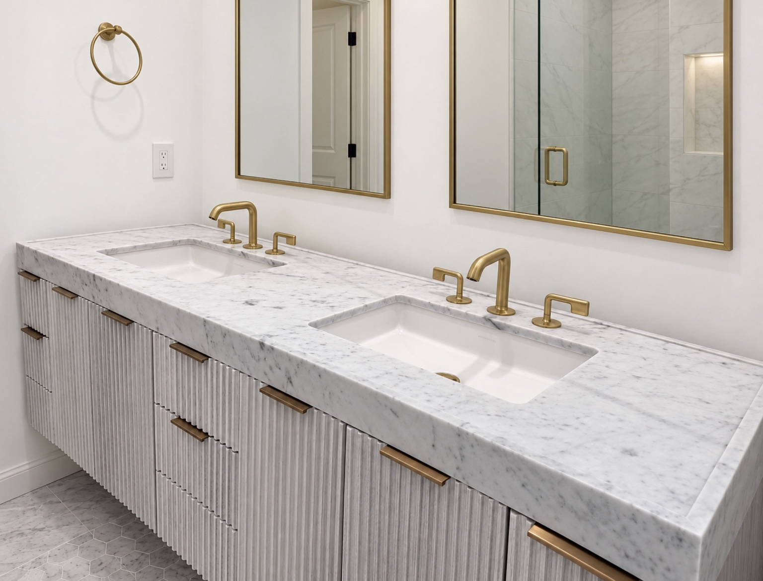 White and gray marble double vanity top with a thick edge, two rectangular sinks, brass faucets and fluted cabinetry