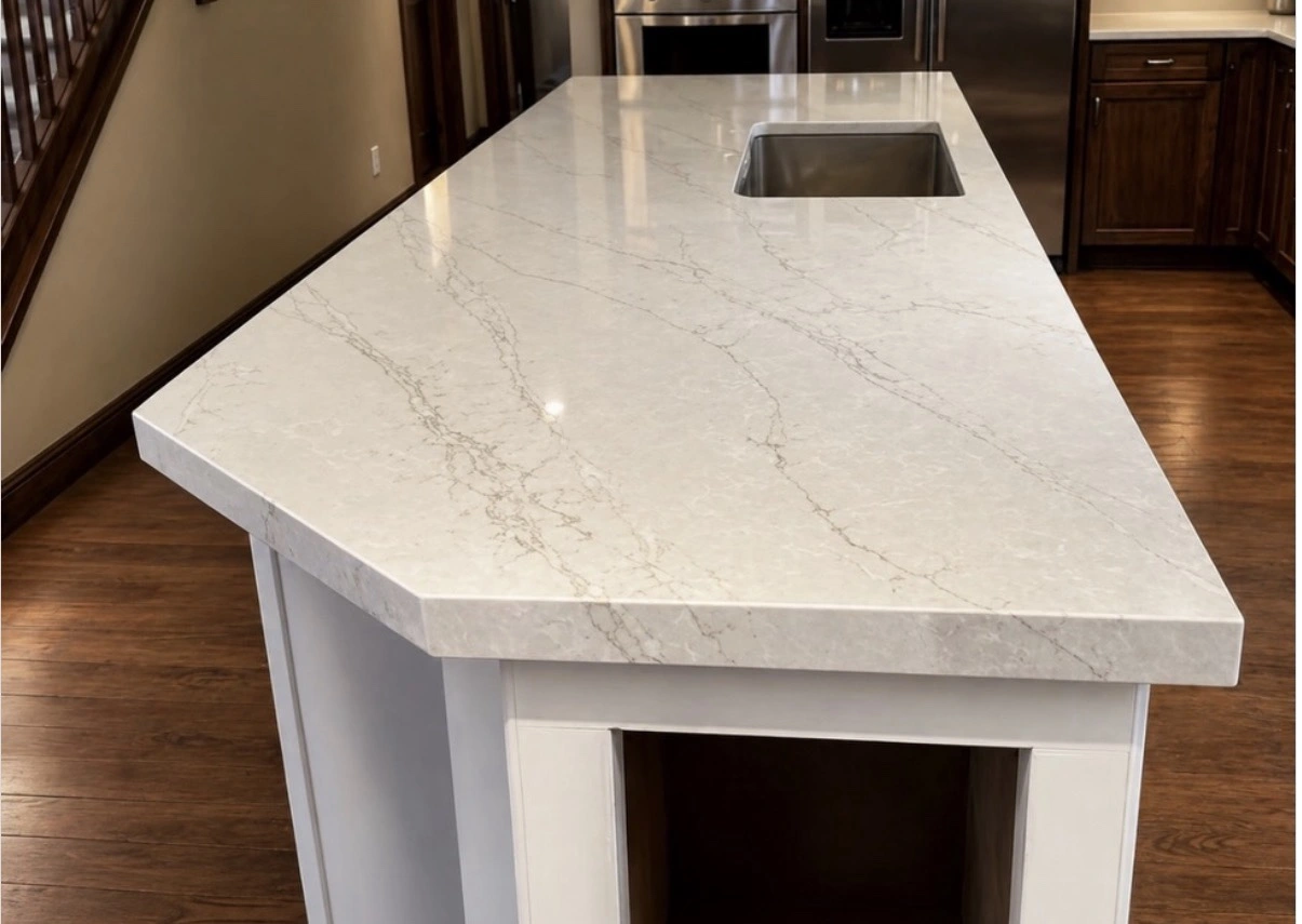 Final result: installed pale veined stone island countertop with an undermount stainless steel sink and white island cabinetry
