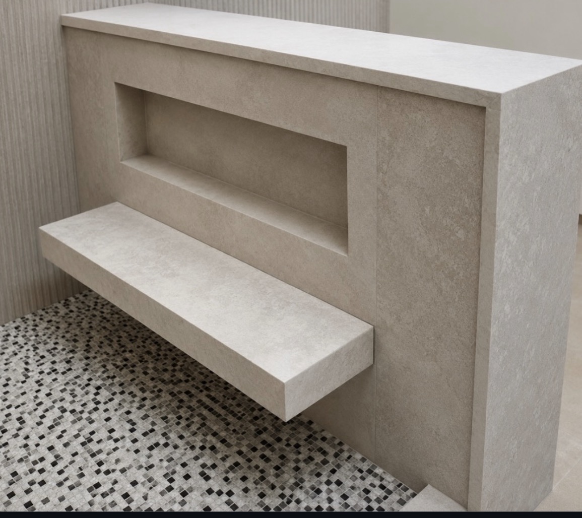 Limestone floating shower seat with mitered box construction, a recessed niche, and a ledge with waterfall panel