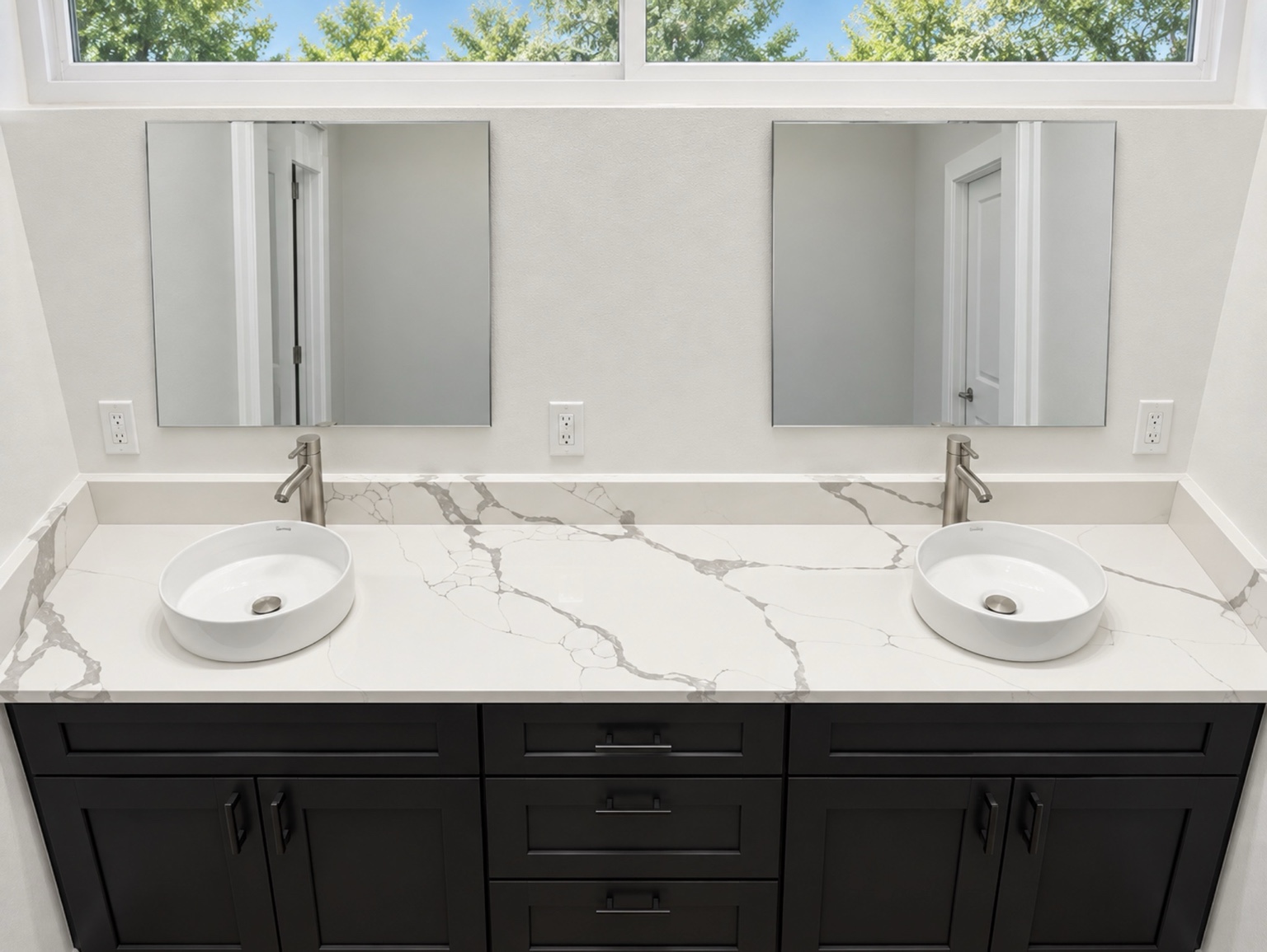 White quartz bathroom vanity top with gray veining, a matching 4-inch slab backsplash and side splashes, two round vessel sinks and dark cabinetry