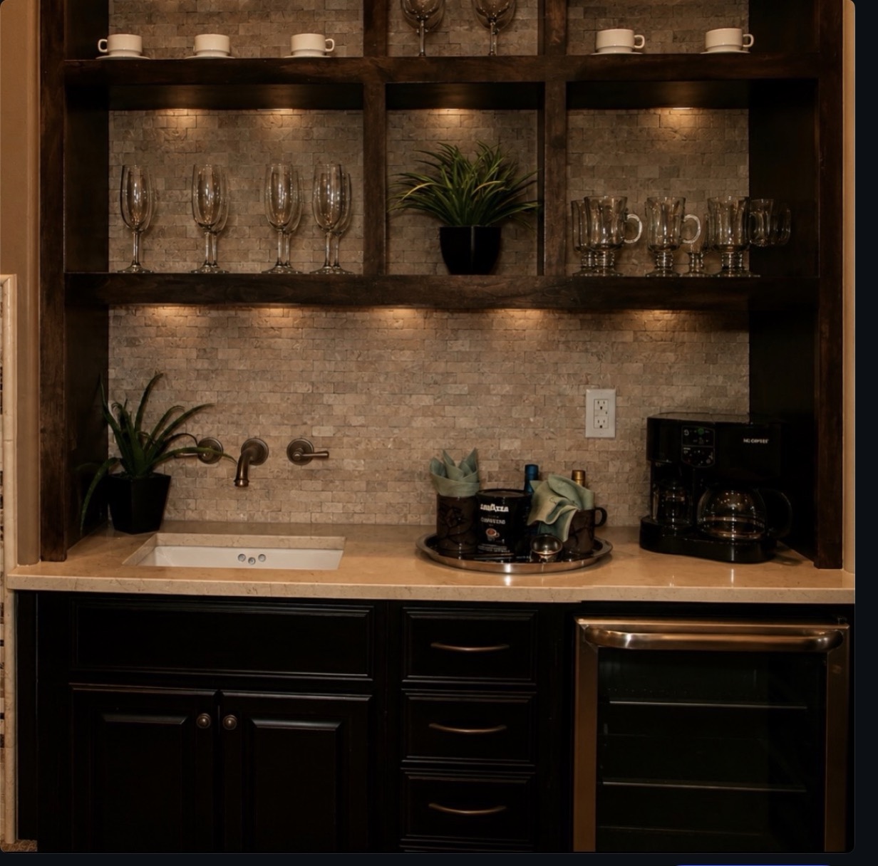 Quartz wet bar countertop with 3 cm square eased edges, an undermount sink, wall-mounted faucet, dark cabinetry and beverage cooler