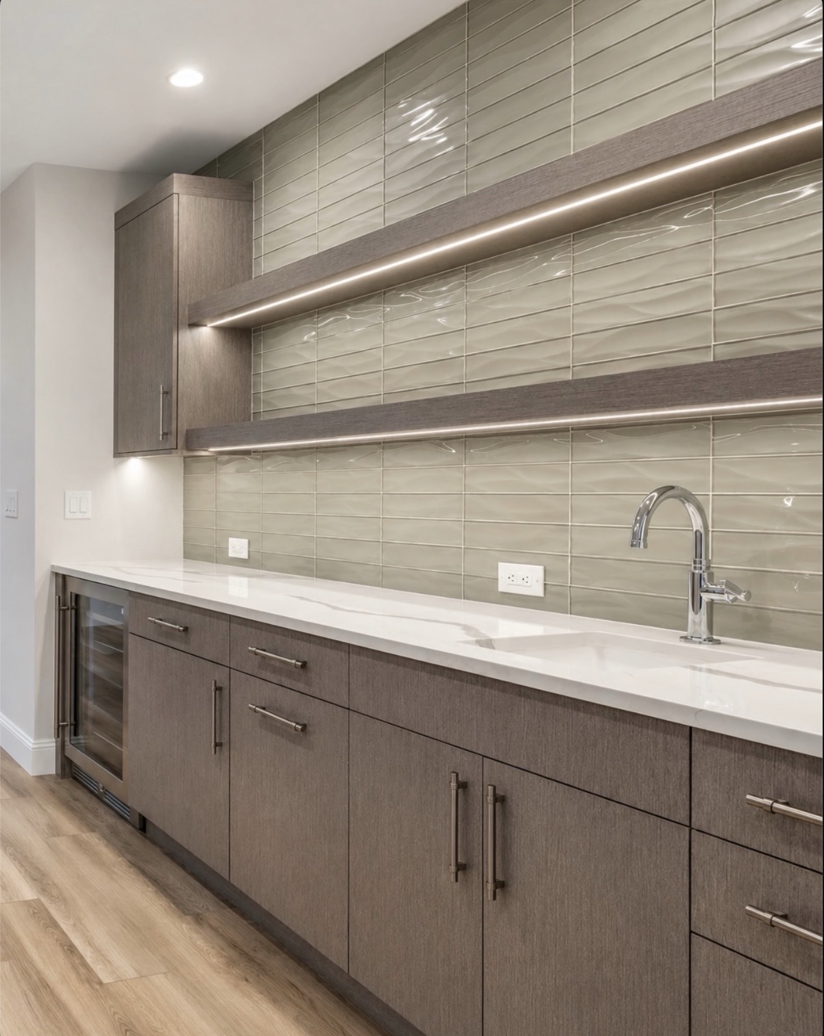 White veined quartz wet bar countertop with a sink, chrome faucet, wood cabinets, beverage cooler and illuminated floating shelves