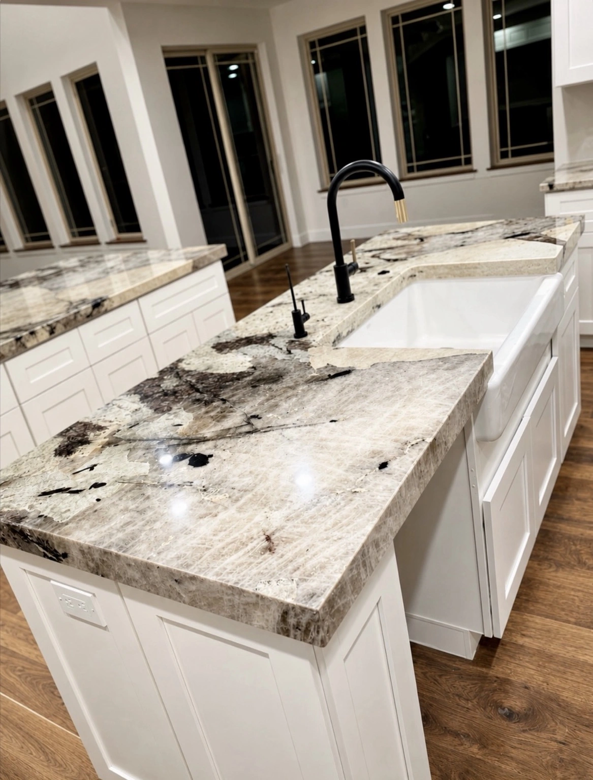 Final result: quartzite kitchen countertops with a 2½-inch mitered edge, white cabinetry and an apron-front sink